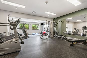 A gym with treadmills, exercise bikes, and other equipment.